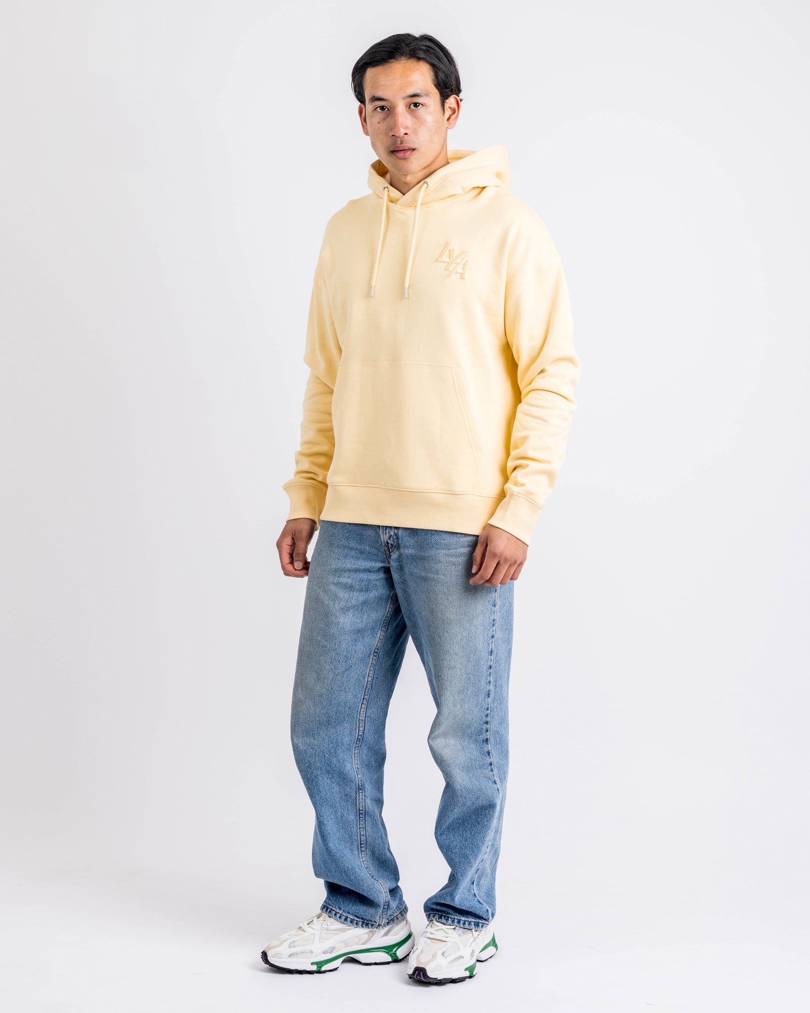 Model styling the Sunny Yellow Organic Cotton Hoodie by LoveYouAll in a casual urban outfit, highlighting comfort and design